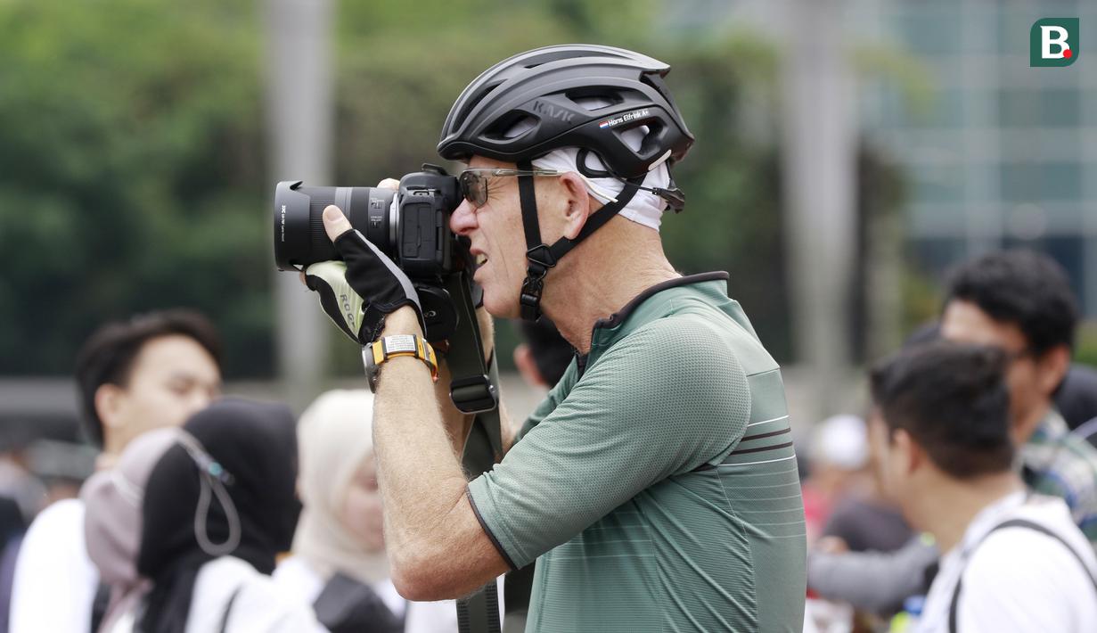 Seorang warga asing asyik mengabadikan momen suasana Car Free Day di Jakarta. (Bola.com/M Iqbal Ichsan)
