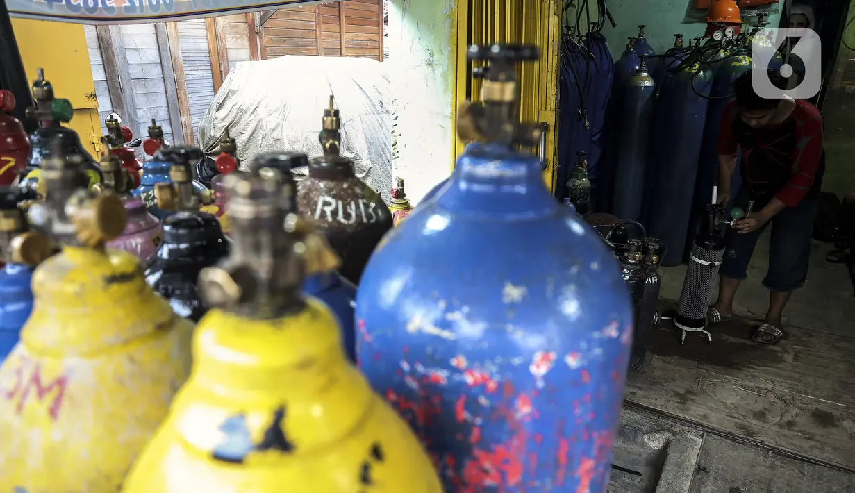 Pekerja merapikan tabung oksigen di agen isi ulang oksigen Tiga Saudara kawasan Joglo Raya, Jakarta Barat, Kamis (17/6/2021). Dalam sehari, tak sedikit juga warga mengisi ulang oksigen dengan harga Rp 25.000 per kubik. (Liputan6.com/Johan Tallo)