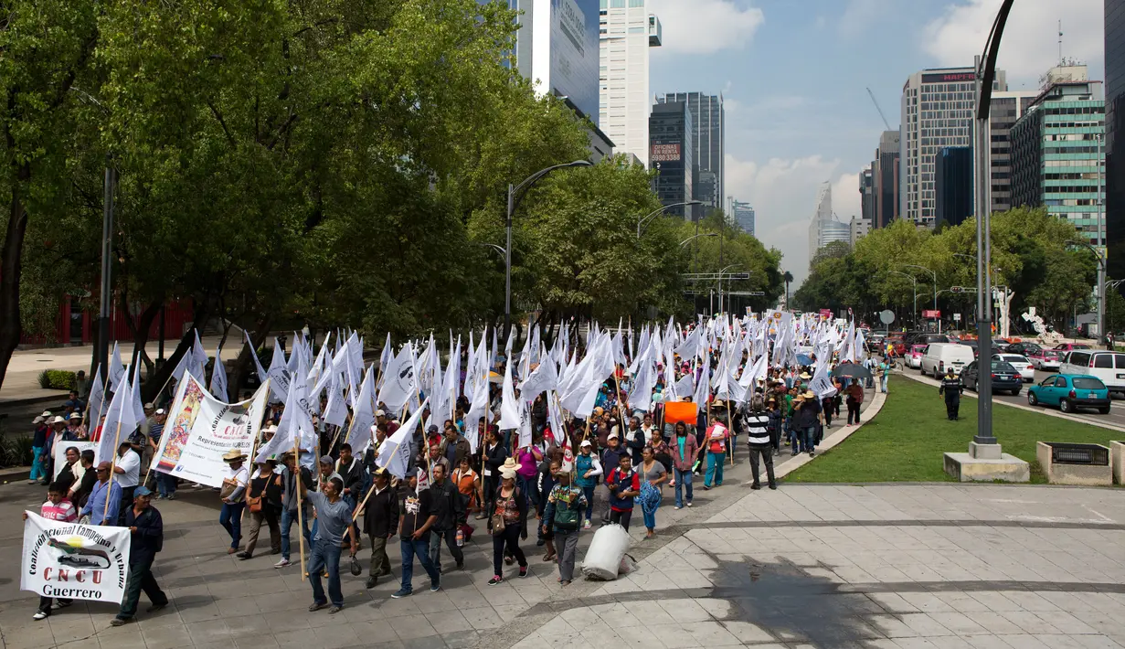 Ribuan petani Meksiko melakukan demontrasi terkait North American Free Trade Agreement (NAFTA) di Mexico City (26/7). Harga impor biji-bijian dari AS tersebut dinilai dapat mematikan harga dan produksi petani lokal di Meksiko. (AP Photo/Rebecca Blackwell)