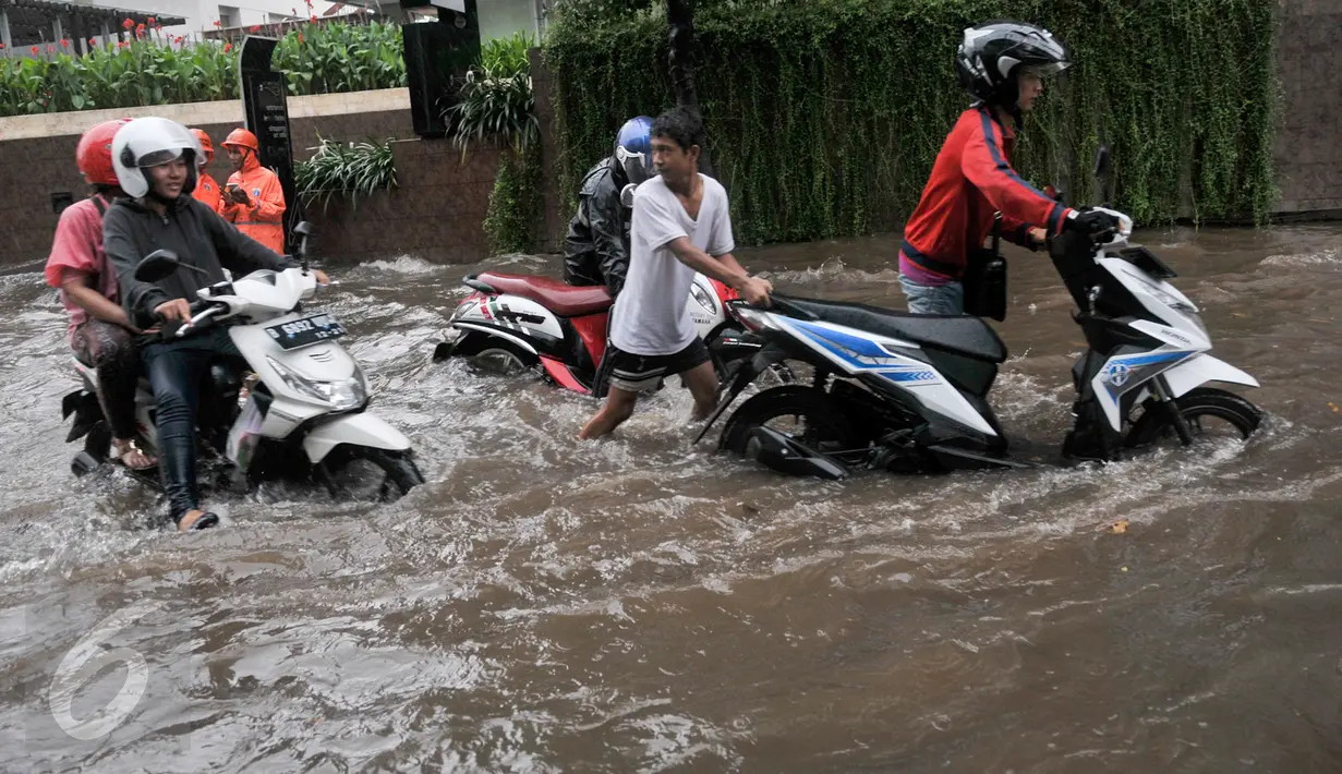 Pengendara mendorong kendaraanya yang mogok akibat menerobos banjir di kawasan Kemang, Jakarta Selatan, Rabu (26/4). Hujan deras yang menguyur kawasan Jakarta menyebabkan banjir di sejumlah kawasan. (Liputan6.com/Yoppy Renato)