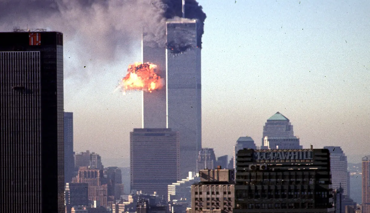 Foto file asap dan api meletus dari menara kembar World Trade Center setelah pesawat komersial sengaja menabrak gedung-gedung di Manhattan, New York pada 11 September 2001. (AFP/Seth Mcallister)