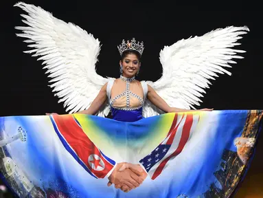 Miss Singapura, Zahra Khanum menampilkan kostum nasionalnya dalam ajang Miss Universe 2018 di provinsi Chonburi, Thailand, Senin (10/12). Khanum mengenakan gaun bergambar pertemuan antara Donald Trump dan Kim Jong-un (Lillian SUWANRUMPHA/AFP)