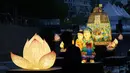<p>Seorang pengunjung yang mengenakan masker untuk membantu mengekang penyebaran virus corona mengambil foto di dekat lentera yang dipajang untuk merayakan ulang tahun Buddha yang akan datang pada 8 Mei, di aliran umum di Seoul, Korea Selatan, Selasa, 26 April 2022. (AP Photo /Lee Jin-man)</p>
