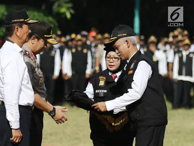 Ketua Pokdarkamtibmas Polda Metro Jaya Heru Riyadi memberikan rompi ke Wakapolda Metro Jaya, Brigjen Pol Purwadi saat apel besar di lapangan Sabhara Mapolda Metro Jaya, Jakarta, Sabtu (12/5). (Liputan6.com/Herman Zakharia)