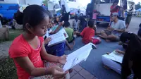 Sejumlah anak membaca buku di mobil Perpustakaan Keliling Dinas Perpustakaan dan Arsip Daerah Kabupaten Klungkung di lokasi pengungsian korban evakuasi Gunung Agung, Klungkung, Bali, Sabtu (30/09). (Liputan6.com/Gempur M Surya)