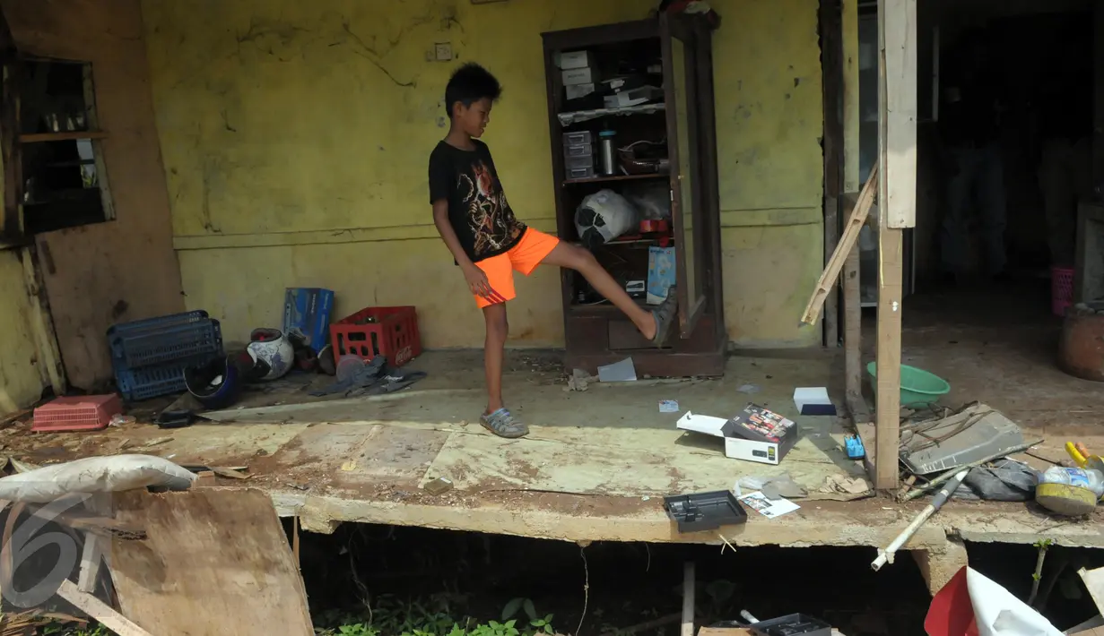 Seorang anak berada di sebuah bangunan semi permanen saat penertiban kawasan hiburan malam Alang-alang di Kelurahan Buaran, Tangsel, Kamis (12/5). Puluhan aparat gabungan diterjunkan untuk menertibkan kawasan hiburan tersebut. (Liputan.com/Helmi Afandi)