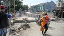 Warga melintas di dekat pembangunan revitalisasi Jembatan Cibubur, Jakarta, Senin (24/10/2022). Jembatan Cibubur yang saat ini sedang direvitalisasi, akan dilengkapi akses untuk pejalan kaki. Jembatan Cibubur yang menghubungkan Pasar Rebo dan Ciracas itu akan ditinggikan guna menghindari genangan ketika permukaan Kali Cipinang meninggi dan ditargetkan selesai pada bulan November 2022. (Liputan6.com/Faizal Fanani)