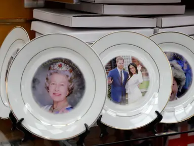 Suvenir piring untuk pernikahan Pangeran Harry dan Meghan Markle dijual di sebuah toko di London, Inggris, Rabu (28/3). Suvenir tersebut dipajang di samping piring bergambar Putri Diana dan Ratu Elizabeth II. (AP Photo/Matt Dunham)