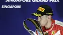 Sebastian Vettel mencium trofi juara F1 GP Singapura di Sirkuit Marina Bay, Singapura, Minggu (20/9/2015). (Reuters/Tim Chong)