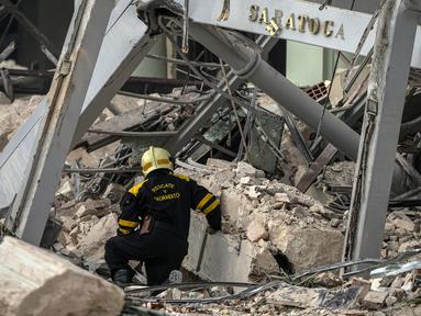 Seorang anggota tim penyelamat mencari korban pada lokasi ledakan mematikan yang menghancurkan Hotel Saratoga di Havana, Kuba, 6 Mei 2022. Ledakan kuat yang diduga disebabkan oleh kebocoran gas alam menewaskan 18 orang dan melukai puluhan orang. (AP Photo/Ramon Espinosa)