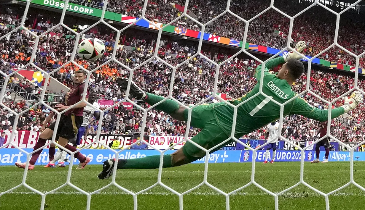 Kiper Timnas Belgia, Koen Casteels gagal menjangkau bola hasil tendangan striker Timnas Prancis, Randal Kolo Muani yang sempat membentur kaki Jan Vertonghen pada laga babak 16 besar Euro 2024 di Merkur Spiel-Arena, Dusseldorf, Jerman, Senin (1/7/2024). (AP Photo/Martin Meissner)