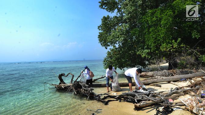 Aktivis Yayasan Kehati Jakarta  membersihkan pantai usai melakukan upacara bendera menghadap laut dalam rangka HUT ke-74 RI di Pulau Sangiang, Banten, Minggu (18/8/2019). (merdeka.com/Arie Basuki)
