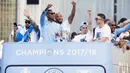Pemain Manchester City berada diatas bus saat melakukan parade juara Premier League di Manchester, Senin (14/5/2018). The Citizens menjadi tim terbaik dengan raihan 100 poin. (AP/Anthony Devlin)