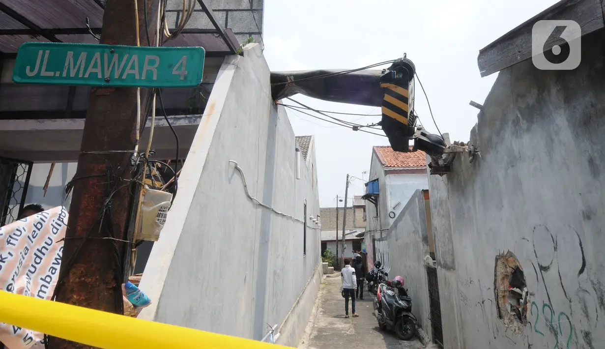 Truk crane yang terguling dan menimpa rumah warga di di Jalan Mawar, Perumnas Depok Jaya, Depok, Jawa Barat, Jumat (15/10/2021). Truk crane di kawasan Proyek PDAM terguling dan menimpa rumah menyebabkan tiga warga mengalami luka serius. (merdeka.com/Arie Basuki)