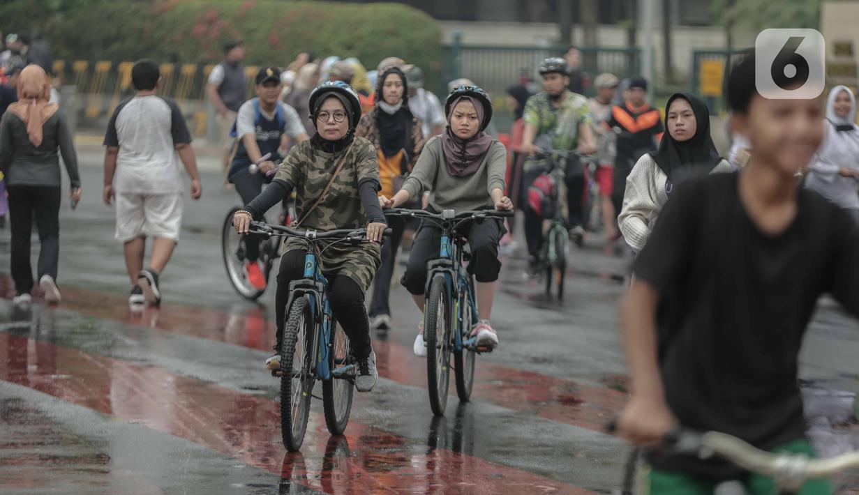 Warga bersepeda saat car free day (CFD) di kawasan Bundaran HI, Jakarta, Minggu (29/12/2019). Kendati tidak seramai saat cerah, warga yang berlari, jalan santai, atau swafoto masih menjadi pemandangan di area CFD usai hujan mengguyur Jakarta. (Liputan6.com/Faizal Fanani)