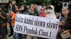 Sejumlah mahasiswa dari berbagai kampus berunjuk rasa di SDN Pondok Cina 1 Depok, Jawa Barat, Selasa (13/12/2022). Dalam aksinya, mereka menolak relokasi SDN Pondok Cina 1 yang lahannya akan digunakan untuk pembangunan masjid. (Liputan6.com/Faizal Fanani)
