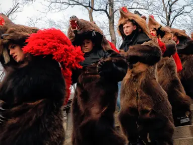 Sejumlah remaja mengenakan kostum beruang menari selama ritual tahunan di Piatra Neamt, Rumania Utara (28/12). Para peserta mengenakan kostum beruang untuk menangkal kejahatan di Tahun Baru. (AP Photo/Vadim Ghirda)