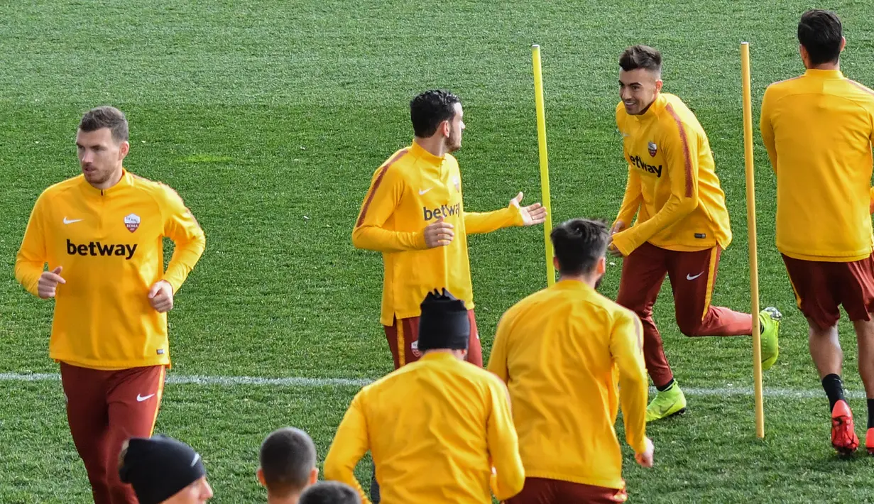 Para pemain AS Roma melakukan pemanasan saat mengikuti sesi latihan di Trigoria, selatan Roma (11/2). AS Roma akan bertanding melawan Porto pada babak 16 besar Liga Champions di stadion Olimpico. (AFP Photo/Andreas Solaro)
