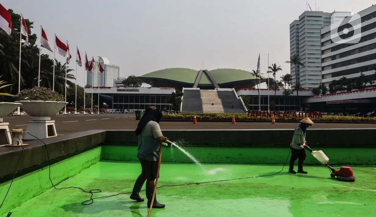 Petugas membersihkan area depan Gedung MPR/DPR/DPD yang meliputi Kolam, Halaman, Lobi gedung Nusantara  Jakarta, Rabu (29/7/2020). Menjelang bulan Agustus yang juga Perayaan Kemerdekaan RI, Parlemen bersolek menyambut sidang Tahunan yang diselenggarakan 14 Agustus 2020. (Liputan6.com/Johan Tallo)