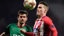 Pemain depan Atletico Madrid Kevin Gameiro mengontrol bola berusaha melewati pemain Lokomotiv Moskow saat pertandingan Liga Europa leg pertama di stadion Wanda Metropolitano, Madrid (8/3). (AFP/Javier Soriano)