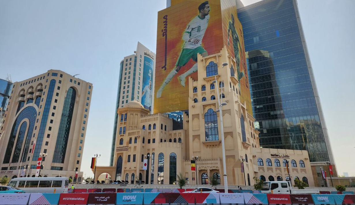 <p>Gambar pesepak bola Timnas Arab Saudi, Salem Al-Dawsari memenuhi salah satu gedung yang terletak di kota Doha, Qatar pada Jumat (19/11/2022). (Dok. SCM)</p>