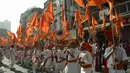 Sejumlah peserta menari sambil membawa bendera saat merayakan Gudhi Padwa di Mumbai, India (28/3). Masyarakat setempat percaya bahwa apapun yang di beli pada hari Gudhi Padwa ini akan memberikan keuntungan. (AFP/Punit Paranjpe)