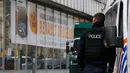 Polisi berjaga-jaga dekat dearler mobil setelah ditangkapnya buronan penyerangan Paris Mohamed Abrini di Anderlecht, Belgia, (8/4). Mohamed Abrini tak berkutik ketika dibekuk pasukan khusus Belgia. (REUTERS/Yves Herman)