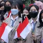 Siswa SMA sedang memegang bendera merah putih.