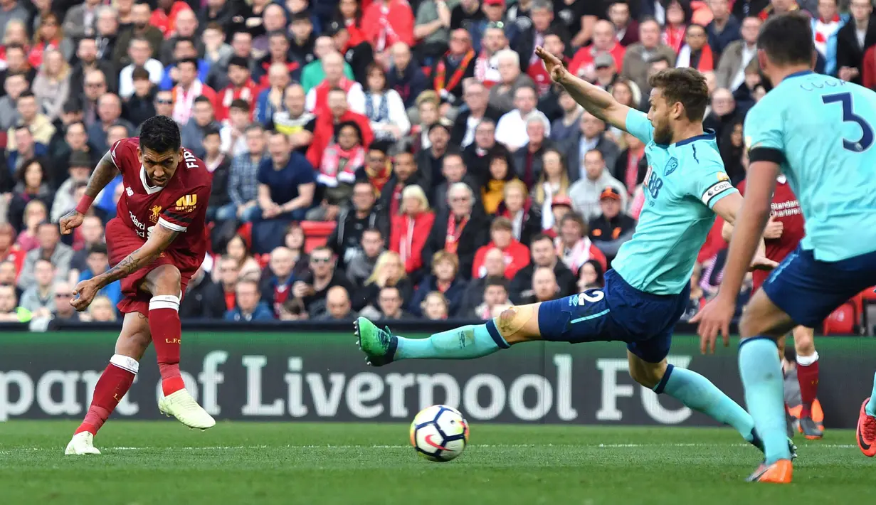 Pemain Liverpool Roberto Firmino melakukan tendangan yang akhirnya membuahkan gol ketiga untuk timnya saat melawan Bournemouth pada pertandingan Liga Inggris di Anfield, Liverpool (14/4). (Anthony Devlin/PA via AP)