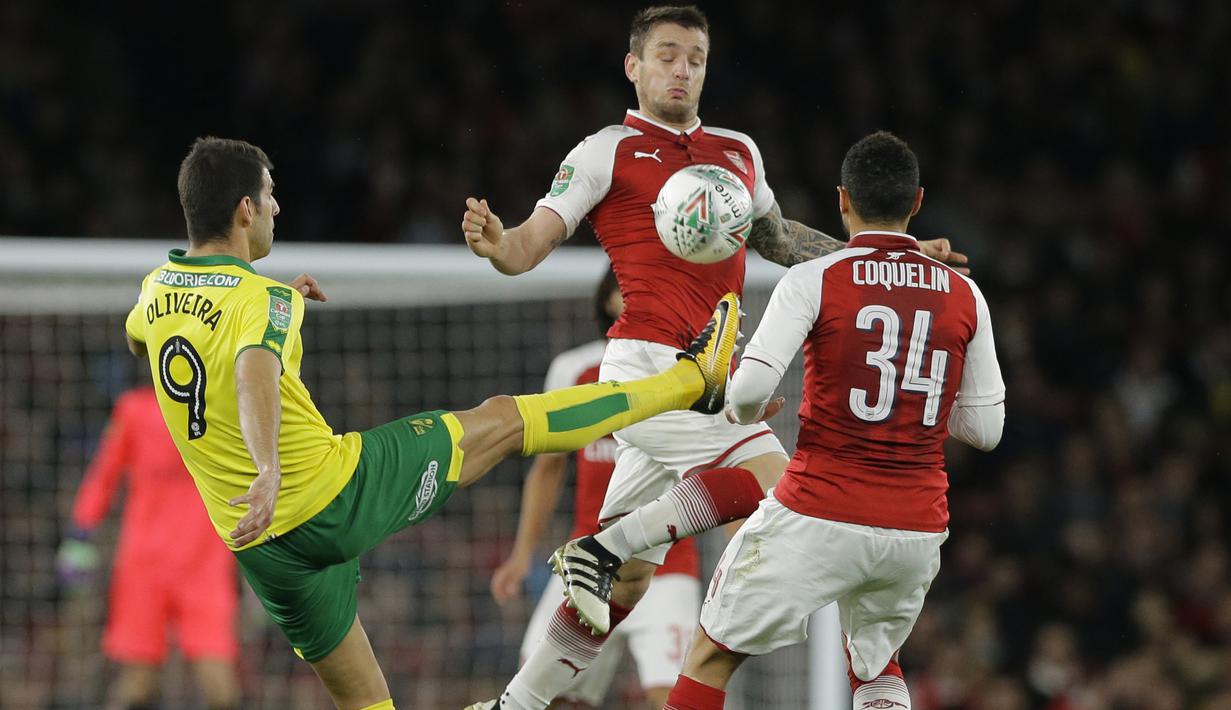 Pemain Arsenal, Mathieu Debuchy (tengah) mengadang sepakan pemain Norwich City, Nelson Oliveira (kiri) pada laga Piala Liga Inggris di Emirates Stadium, London, (24/10/2017). Arsenal menang 2-1. (AP/Alastair Grant)