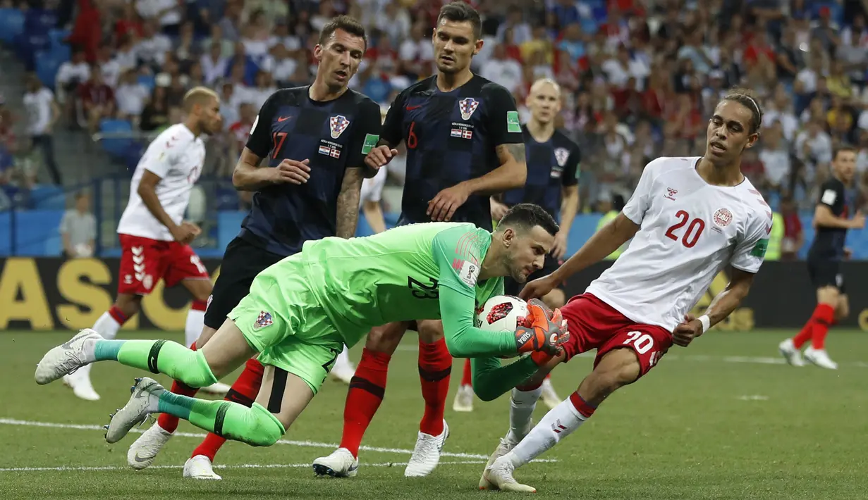 Kiper Kroasia, Danijel Subasic mengamankan bola dari kejaran pemain Denmark, Yussuf Yurary Poulsen pada laga 16 besar Piala Dunia 2018 di Nizhny Novgorod Stadium, Rusia, (1/7/2018). Kroasia menang 3-2 lewat adu penalti. (AP/Darko Bandic)