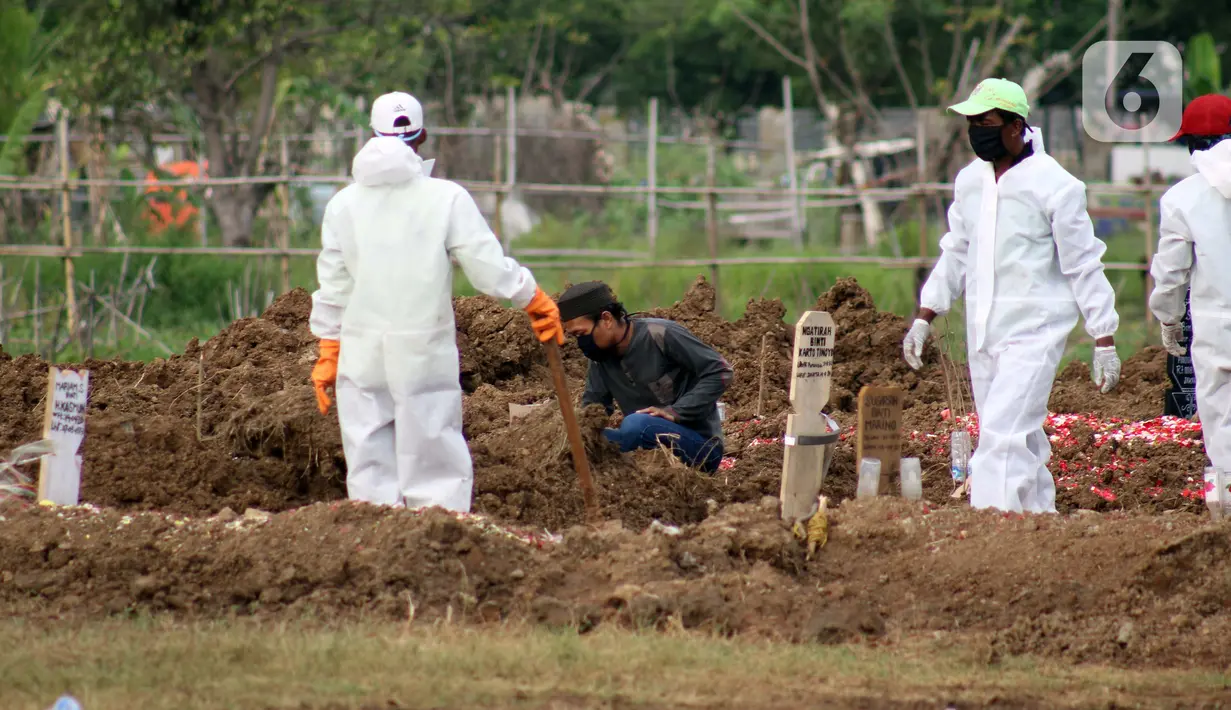 Salah satu kerabat mengazankan pasien Covid-19 usai pemakaman di TPU Tegal Alur, Jakarta, Rabu (15/4/2020). Pemprov DKI Jakarta menyediakan dua TPU yang dijadikan lokasi pemakaman pasien meninggal akibat Covid-19, yakni TPU Pondok Ranggon dan Tegal Alur. (Liputan6.com/Helmi Fithriansyah)