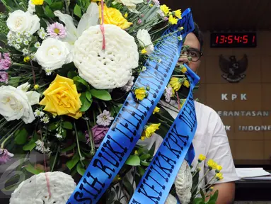 Seorang aktivis membawa karangan bunga yang dihiasi kerupuk saat berkunjung ke KPK, Jakarta, Rabu (16/12/2015). Mereka menolak RUU KPK dan berharap KPK tak melempem seperti kerupuk. (Liputan6.com/Helmi Afandi)
