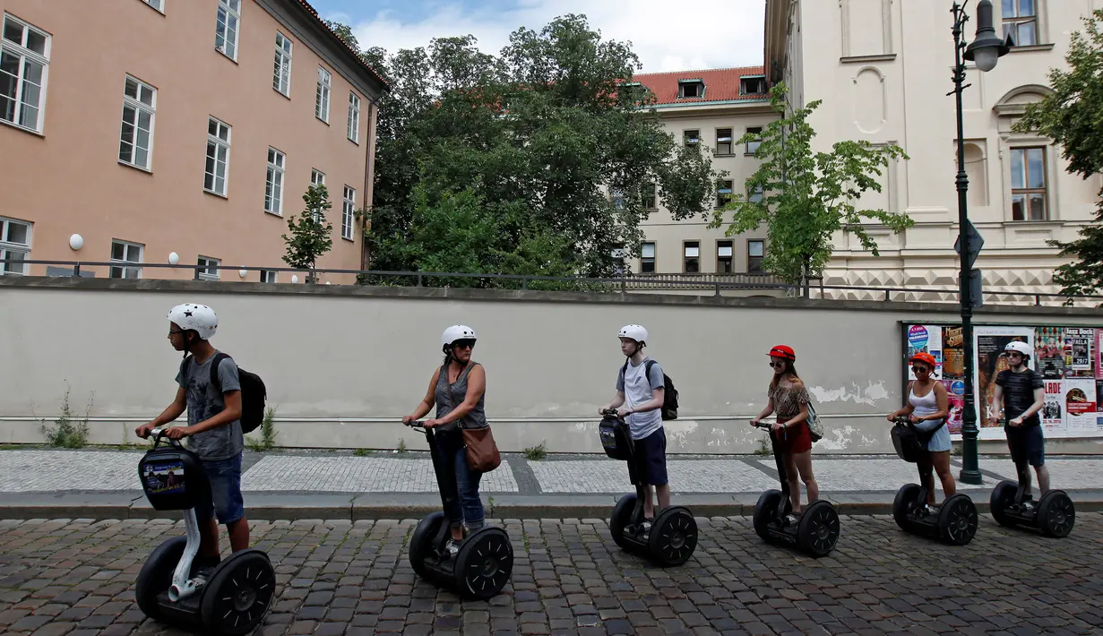 Sejumlah turis menggunakan segway untuk menikmati keindahan kota dan bangunan tua di pusat kota Praha, Ceko, Selasa (19/7). Segway adalah kendaraan personal listrik beroda 2 yang mampu menyeimbangkan sendiri. (REUTERS/David W Cerny)