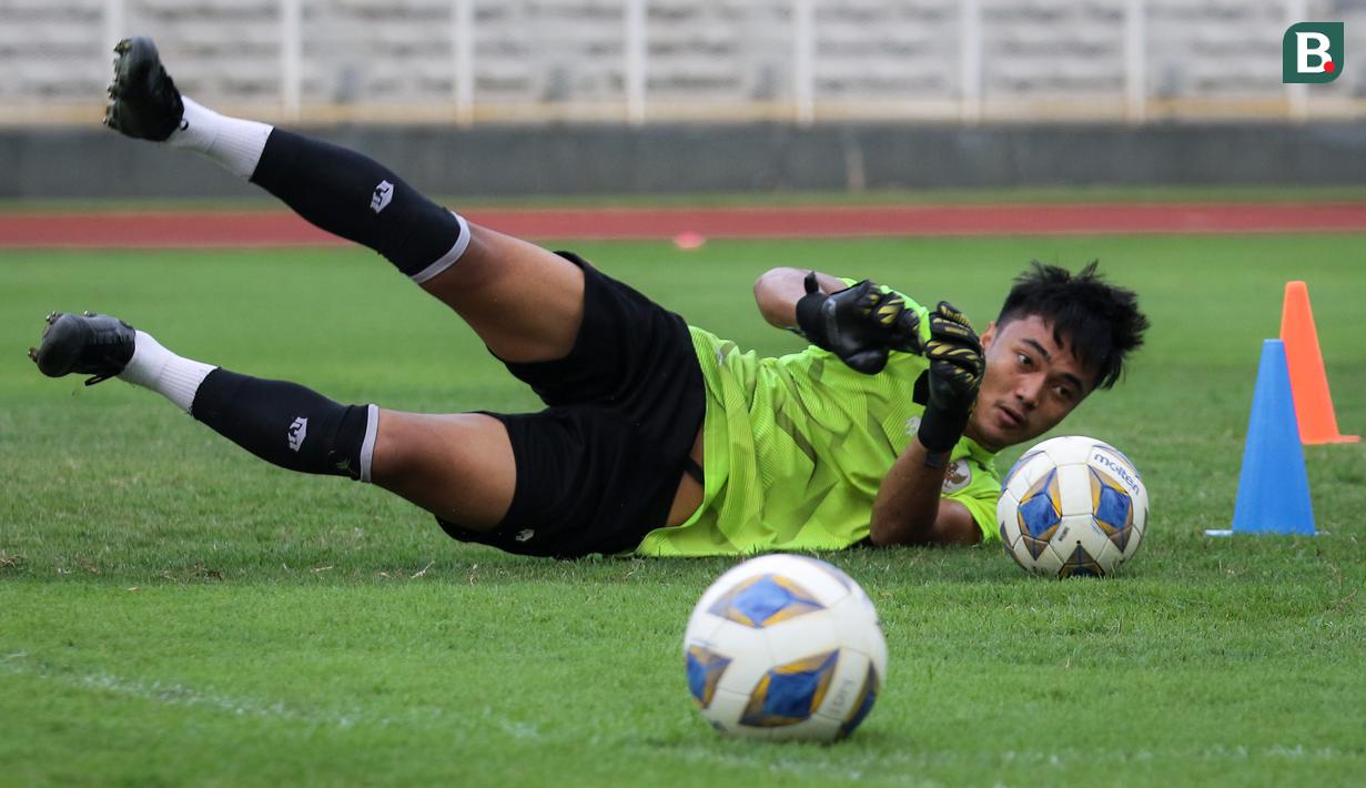 Kiper Timnas Indonesia U-23, Ernando Ari berusaha menyelamatkan bola saat latihan untuk persiapan SEA Games 2021 di Stadion Madya, Senayan, Jakarta, Selasa (12/04/2022) sore WIB. Skuat Garuda Muda rencananya akan berlaga di Hanoi pada 6-22 Mei 2022. (Bola.com/Bagaskara Lazuardi)