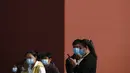  Turis mengenakan masker berdiri di dinding merah saat mereka mengunjungi Kota Terlarang di Beijing (25/10/2020). Dengan wabah COVID-19 yang sebagian besar terkendali di dalam perbatasan China, rutinitas kehidupan sehari-hari yang normal telah mulai kembali untuk warganya. (AP Photo/Andy Wong)