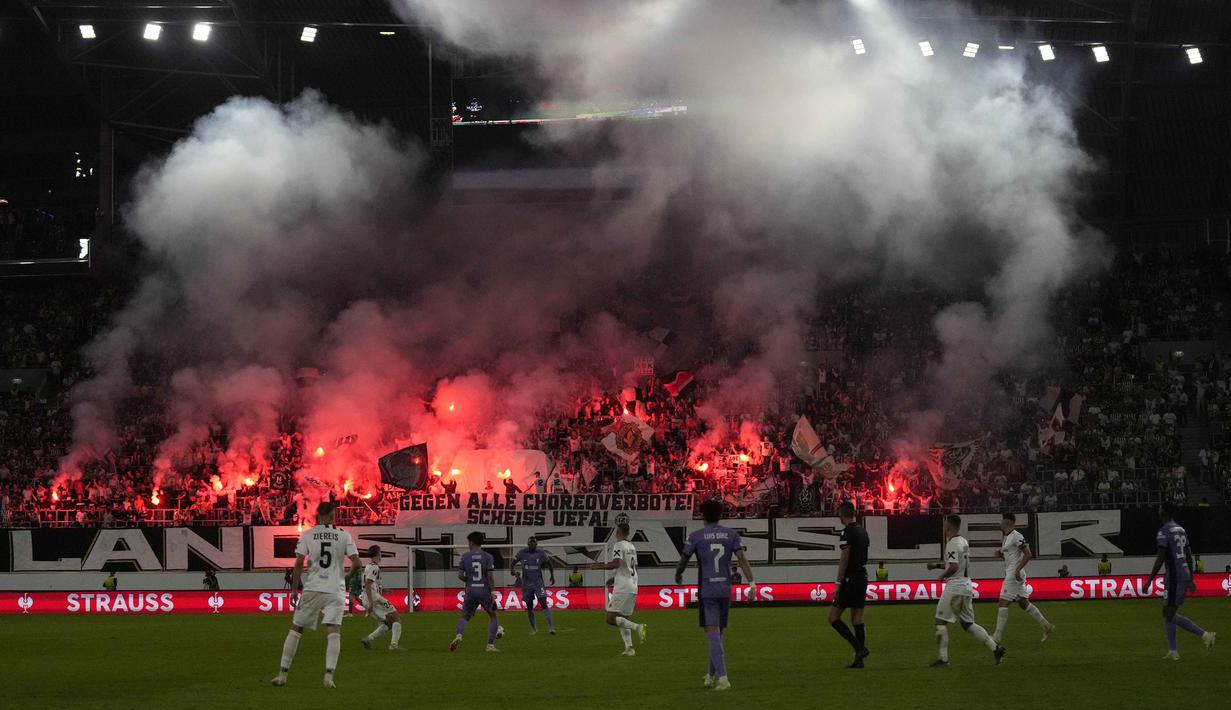 Pendukung Linzer ASK menyalakan suar saat laga Grup E Liga Europa 2023/2024 melawan Liverpool di Linz, Austria, Jumat (22/09/2023). Sempat tertinggal, Liverpool berhasil menang comeback atas Linzer ASK dengan skor 3-1. (AP Photo/Matthias Schrader)