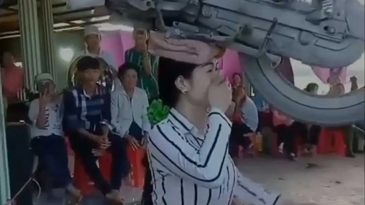 Wanita ini joget sambil gendong motor di atas kepalanya (instagram wuakakak.id)