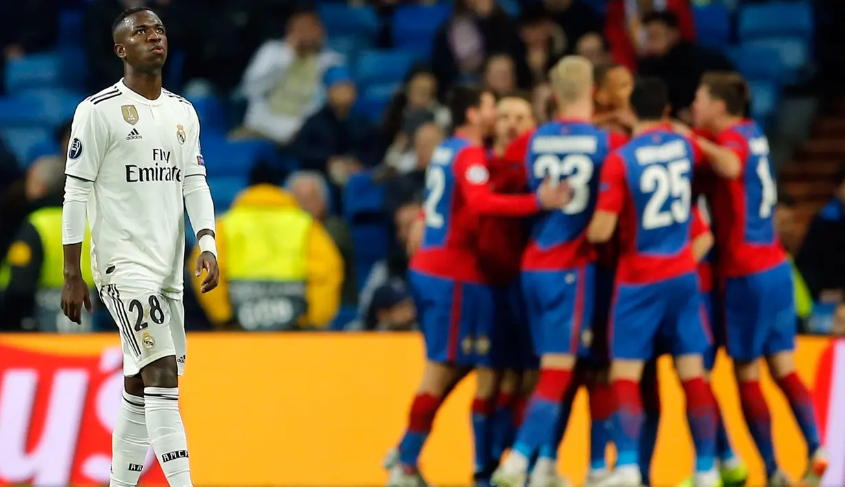 Penyerang Real Madrid, Vinicius Junior terlihat saat pemain  CSKA Moscow merayakan kemenangan mereka pada laga terakhir Grup G Liga Champions di Santiago Bernabeu, Rabu (12/12). Real Madrid secara mengejutkan dipecundangi CSKA Moscow 0-3. (AP/Paul White)