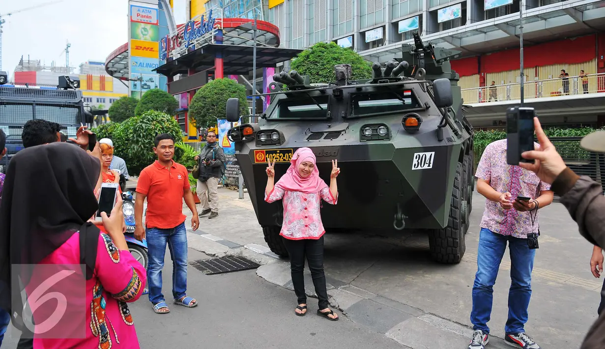 Seorang perempuan berselfie di depan panser Anoa milik TNI di LTC Glodok, Jakarta, Jumat (4/11). Anoa itu diparkir di depan LTC Glodok untuk mengantisipasi jika terjadi kerusuhan di pusat perbelanjaan tersebut. (Liputan6.com/Angga Yuniar)