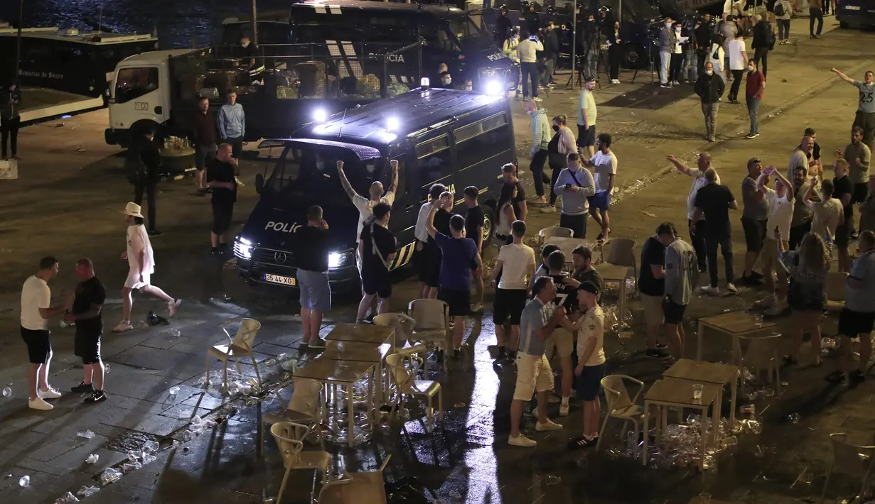 Sebuah van polisi membubarkan suporter Manchester City yang rusuh di tepi sungai Douro di Porto, Portugal (28/5/2021).  Sejumlah suporter Manchester City bentrok dengan polisi di Porto, Portugal, jelang final Liga Champions. (AP Photo/Luis Vieira)