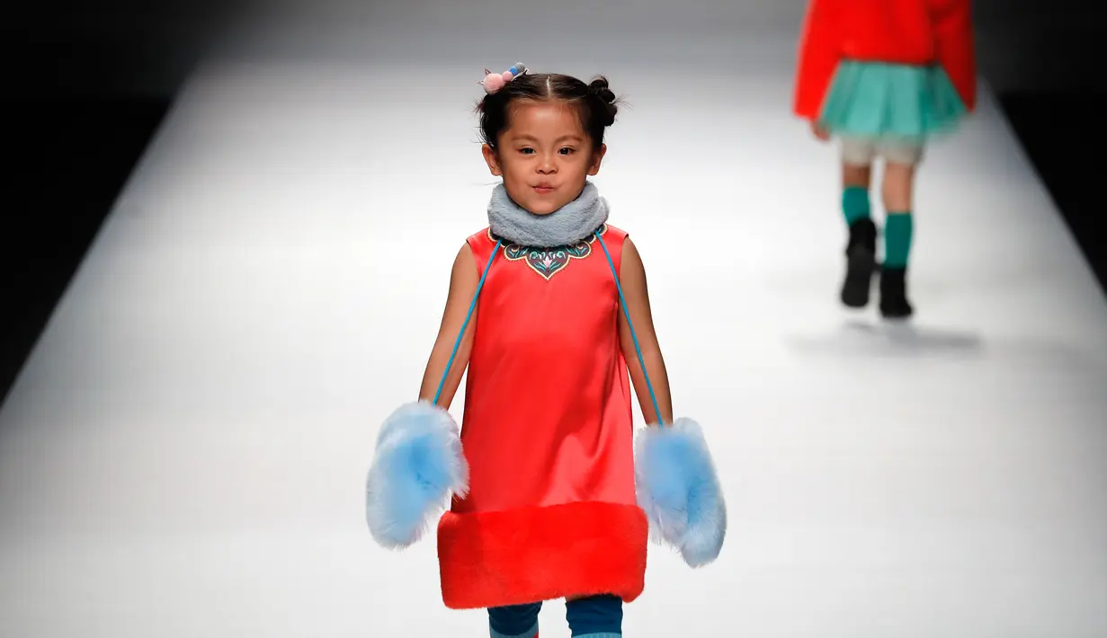 Seorang anak berjalan di atas catwalk memperagakan karya desainer Amelie Wang pada China Fashion Week di Beijing,  31 Oktober 2017. (AP Photo/Andy Wong)