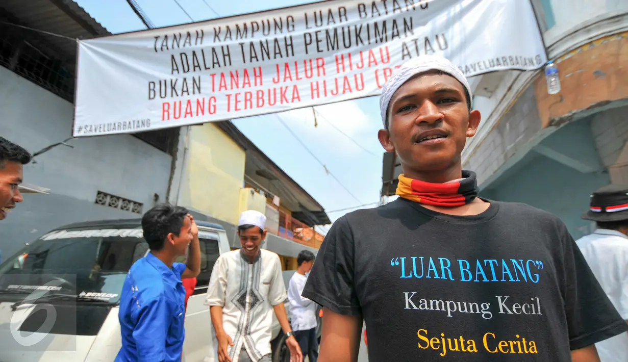 Seorang warga berdiri di dekat spanduk penolakan penggusuran yang terpasang di Kampung Luar Batang, Penjaringan, Jakarta, Rabu (20/4). Mereka menolak pembongkaran tahap dua yang akan dilakukan Pemprov DKI pada Mei nanti. (Liputan6.com/Yoppy Renato)