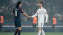 Pemain Paris Saint-Germain (PSG), Edinson Cavani (kiri) menyalami pemain Real Madrid Cristiano Ronaldo setelah timnya kalah pada babak 16 besar Liga Champions di Stadion Parc des Princes, Paris, Prancis, Selasa (6/3). (CHRISTOPHE SIMON/AFP)