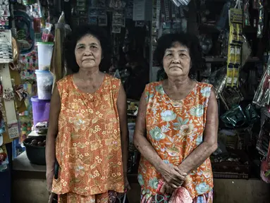 Warga kembar Una dan Uni saat berbelanja di salah satu warung di Kampung Tehyan, Tangerang, Banten, Selasa (9/2/2021). Kampung yang lebih dikenal dengan perkampungan Cina Benteng ini salah satu bukti sejarah lahirnya masyarakat hasil perpaduan Tionghoa dan pribumi. (merdeka.com/Iqbal S. Nugroho)