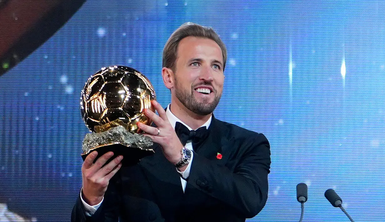 Pesepak bola Inggris, Harry Kane, memegang trofi penghargaan pemain terbaik saat menghadiri acara penganugerahan Ballon d’Or di London Palladium Theatre, London, Inggris, Senin (26/10/2026). (AP Photo/Kin Cheung)