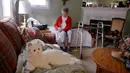 Mary Derr (93) duduk dekat robot kucing yang dipanggil "Buddy" di rumahnya, South Kingstown, 1 Desember 2017. Robot kucing ini memiliki kecerdasan buatan guna membantu orang dengan demensia ringan mengingat yang mungkin mereka lupakan. (AP/Stephan Savoia)