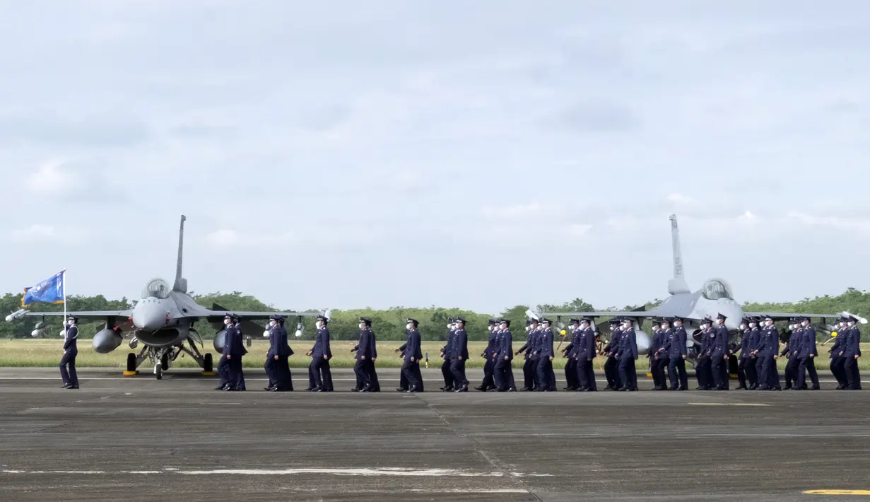 Anggota Angkatan Udara Taiwan berjalan melewati dua jet tempur F-16V yang baru di pangkalan Angkatan Udara di Chiayi, Taiwan barat daya, Kamis (18/11/2021). Langkah Taiwan tersebut untuk meningkatkan kemampuan pertahanannya dalam menghadapi ancaman berkelanjutan dari China. (AP Photo/Johnson Lai)
