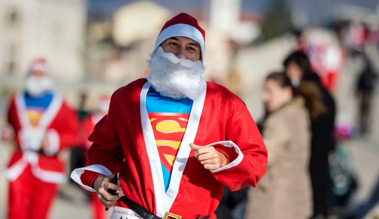 Seorang pria berpakaian Santa Claus dengan kaos Superman ikut serta dalam perlombaan lari tradisional Santa Claus Tahun Baru di Skopje, (24/12) (AFP Photo / Robert Atanasovki)