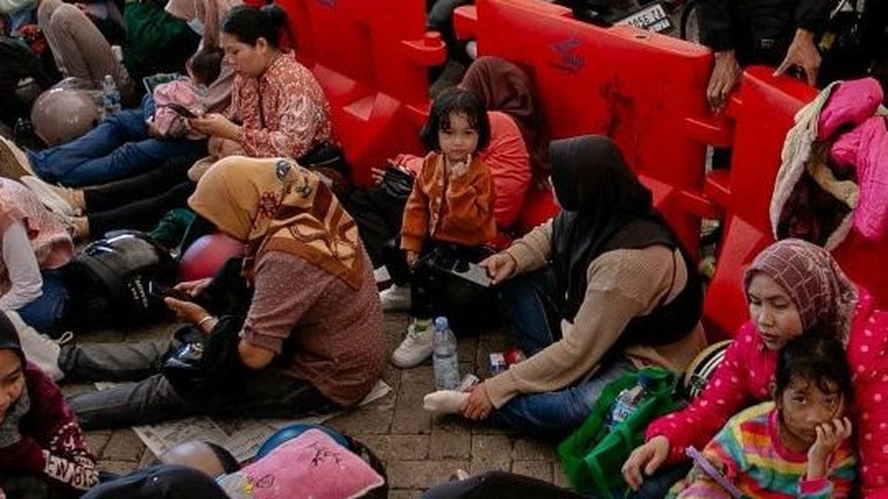 Mayoritas yang kelelahan adalah ibu-ibu dan anak-anak. Mereka memanfaatkan pembatas jalur itu untuk bersandar dan melepas lelah. Foto: liputan6.com / Angga Yuniar